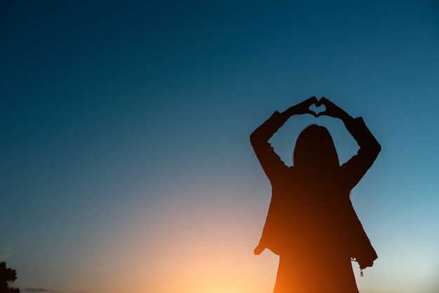 Siluetta della donna simbolo dell'amore sul cielo al tramonto.