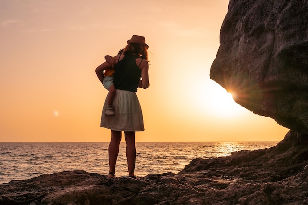 Siluetta della madre e del figlio che abbracciano il bambino al tramonto sulla spiaggia di Tacoron su El Hierro Isole Canarie concetto di vacanza tramonto arancione