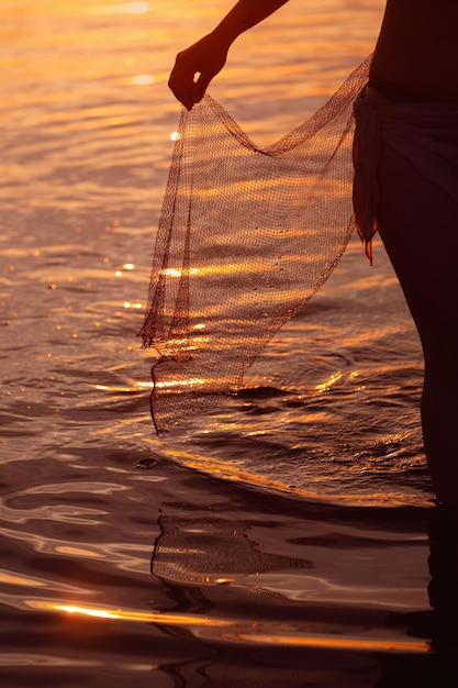 Siluetta della ragazza al tramonto nel fiume Una metà del corpo della donna xA