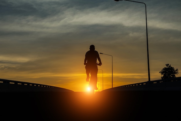 Siluetta di una bici sullo sfondo del cielo al tramonto