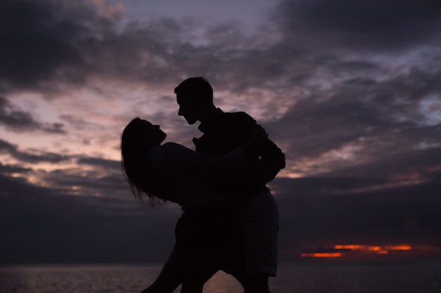 Siluetta di una coppia che balla al tramonto