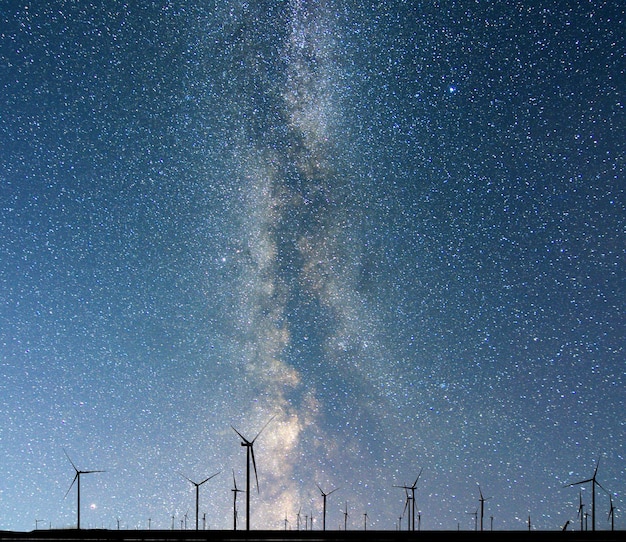 Siluette del parco eolico sul fondo del cielo stellato