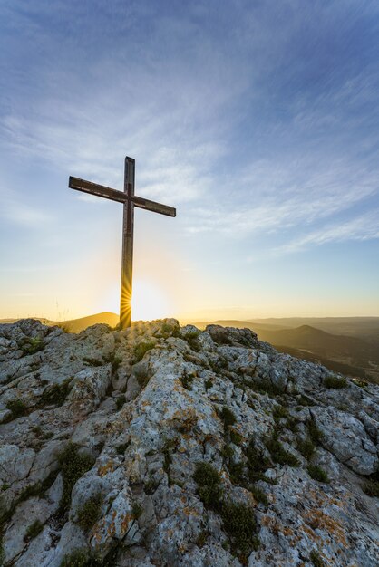 Simbolo cristiano Croce di legno sulla cima di una montagna all'alba