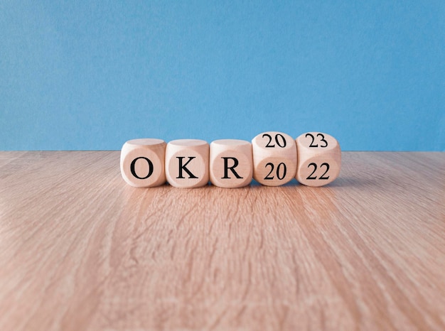 Simbolo degli obiettivi OKR e dei risultati chiave Cubi trasformati con parole OKR 2022 e OKR 2023