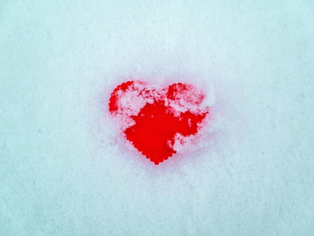 Simbolo del cuore rosso di San Valentino sulla neve bianca