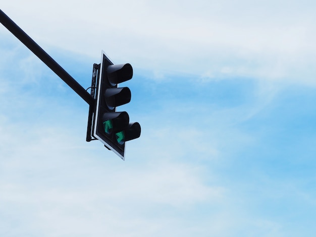 Simbolo della freccia verde sul semaforo contro il cielo blu