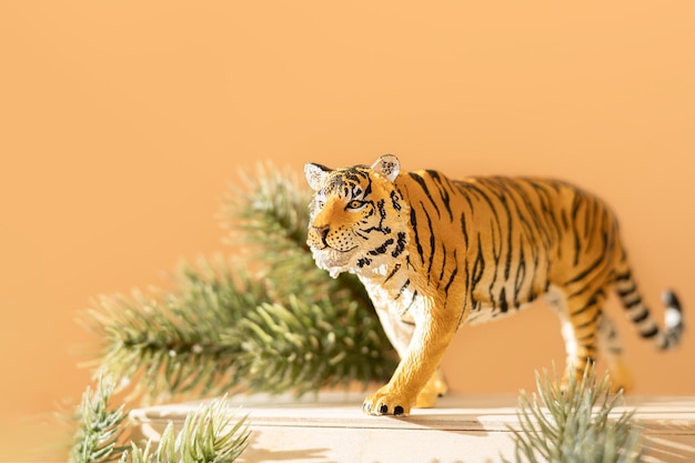 Simbolo della tigre del capodanno cinese 2022. Figurina di tigre con rami di abete rosso su supporto in legno su sfondo luminoso. Copia spazio.