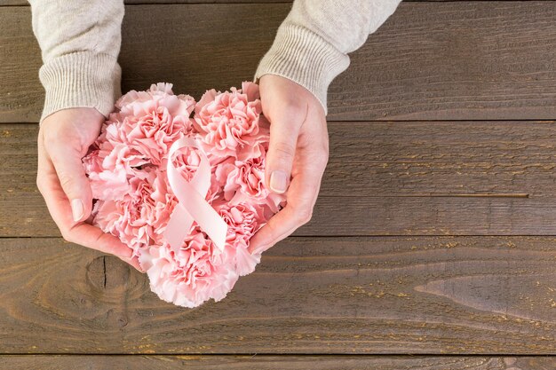 Simbolo di salute delle donne in nastro rosa sul bordo di legno.