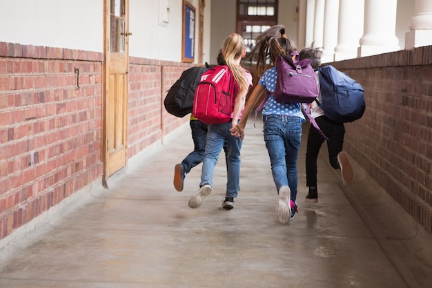 Simpatici allievi che corrono lungo il corridoio