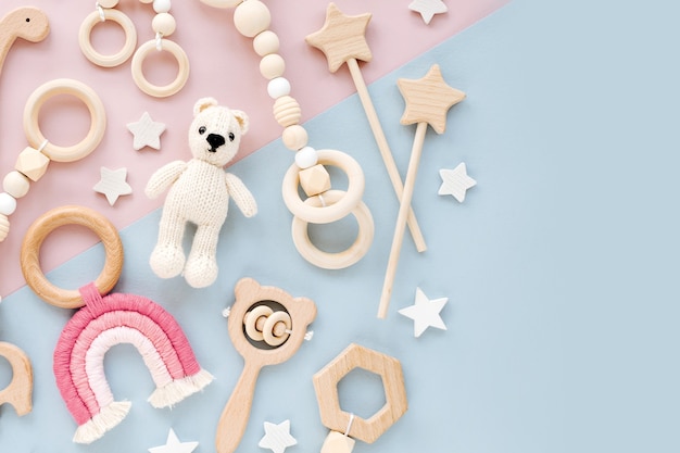 Simpatici giocattoli per bambini in legno su sfondo rosa e azzurro.