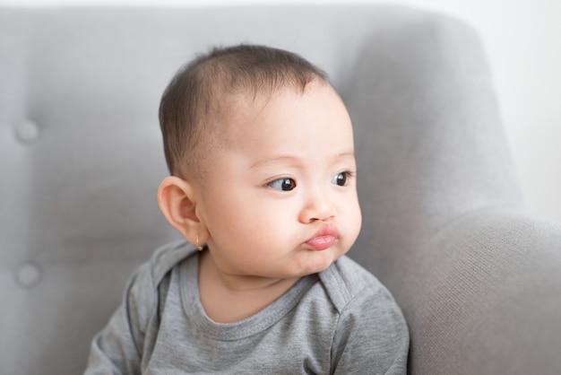 Simpatico bambino che gioca a casa nella stanza grigia