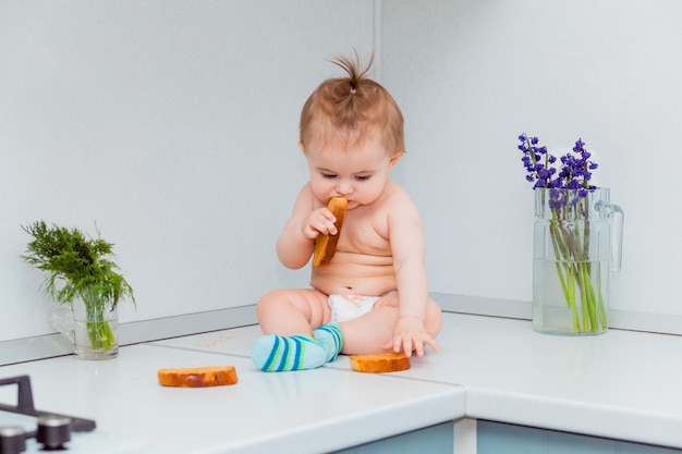 Simpatico bambino con i biscotti seduto sul tavolo in cucina