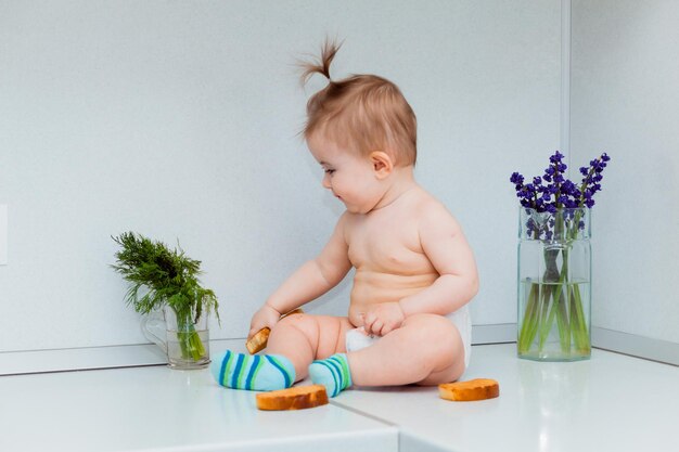 Simpatico bambino con i biscotti seduto sul tavolo in cucina