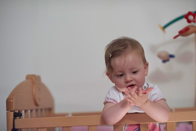 simpatico bambino di un anno che gioca con i giocattoli a letto mentre fa i primi passi e impara a camminare