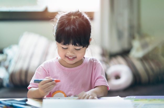 Simpatico bambino dipinto con vernici colorate Ragazza asiatica che usa il colore del disegno a pastello Concetto di stile di vita di attività dell'artista