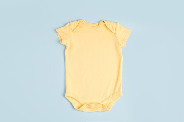 Simpatico body giallo per bebè. Abbigliamento per bambini. Moda neonato. Disposizione piatta, vista dall'alto