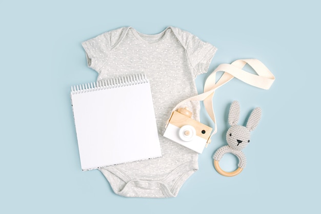 Simpatico body grigio per bebè con carta finta. Set di vestiti e accessori per bambini. Moda neonato. Disposizione piatta, vista dall'alto