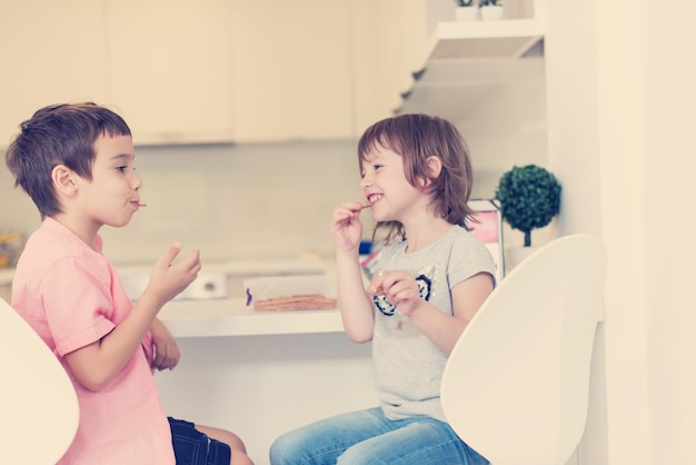 simpatico fratellino e sorella a casa a piedi nudi in cucina divertendosi