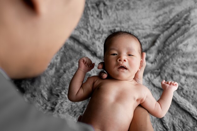 Simpatico neonato portato dalla mano di sua madre