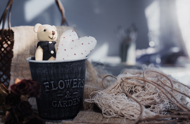 Simpatico orso di San Valentino con cuore bianco in un secchio di alluminio. Concetto di San Valentino
