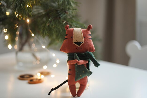 Simpatico peluche tigre con decorazioni su un accogliente sfondo di natale o capodanno simbolo dell'oriente ...