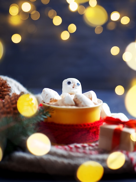 Simpatico pupazzo di neve marshmallow in una tazza di caffè caldo o cioccolata con una sciarpa rossa