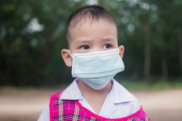 Simpatico ragazzino indossa una maschera per protezione coronavirus o covid 19.