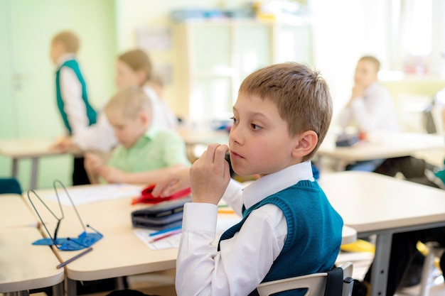 Simpatico ragazzino seduto in classe a scuola