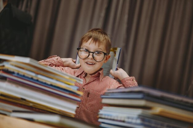 Simpatico ragazzo caucasico con gli occhiali che copre sbirciando da dietro i libri