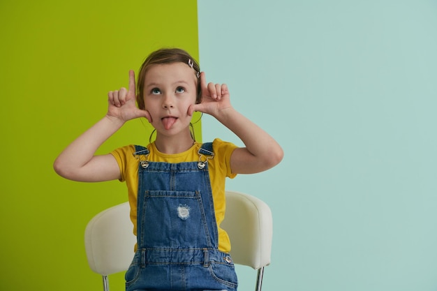 simpatico ritratto di bambini. Bambina sorridente a casa facendo faccia buffa e recitando