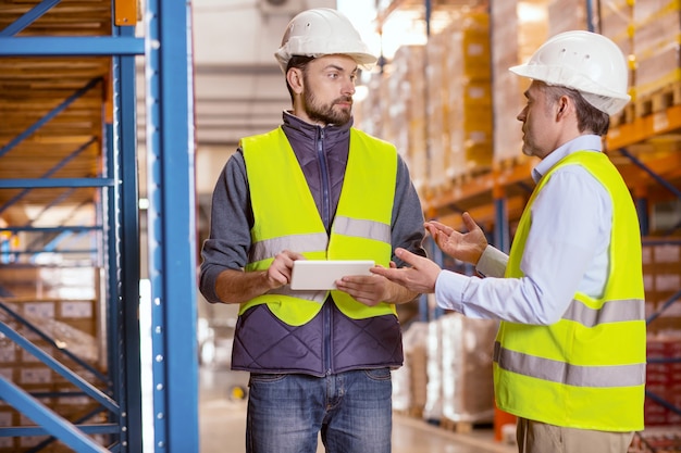 Simpatico uomo intelligente che guarda il suo capo mentre ascolta i suoi desideri sull'ottimizzazione del lavoro