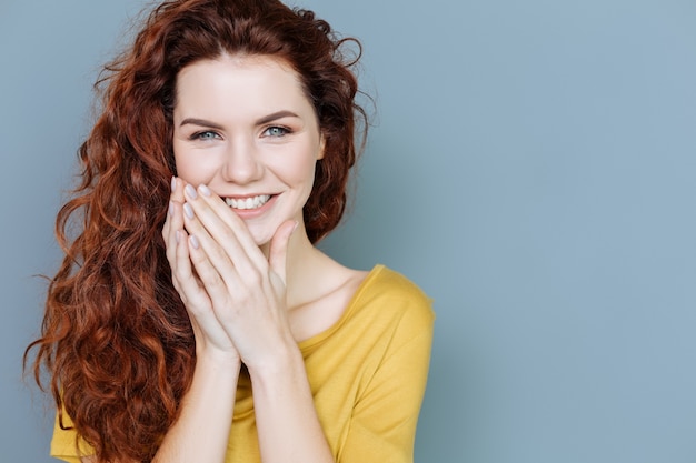 Sincere emozioni. Ritratto di una donna gioiosa felice che sorride e ti guarda mentre esprime le sue emozioni di felicità