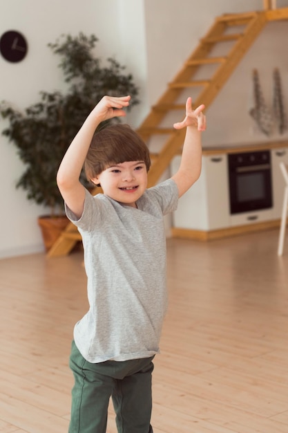 Sindrome di down del bambino che gioca o balla a casa