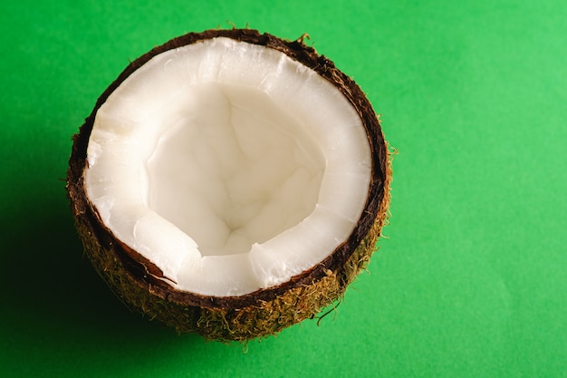 Singolo frutto di cocco su una superficie piana verde