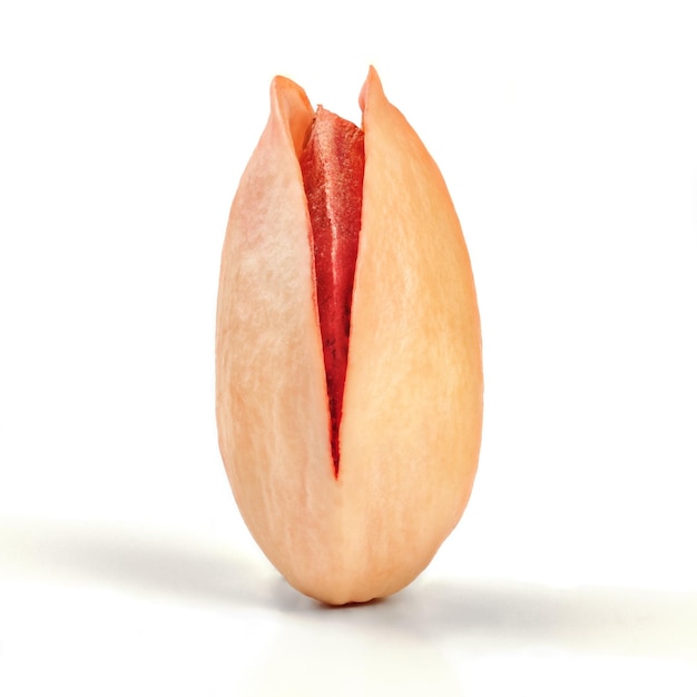 Singolo pistacchio turco rosso tostato con guscio incrinato isolato su sfondo bianco.