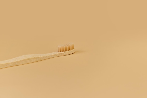 Singolo spazzolino da denti in legno di bambù su sfondo beige