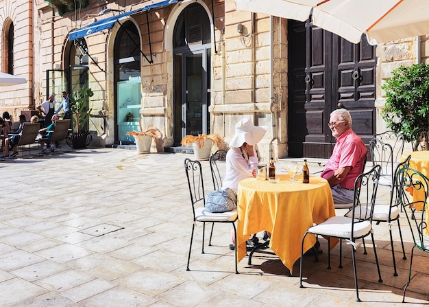 Siracusa, Italia - 28 settembre 2017: Coppia senior nell'accogliente street cafe a Siracusa, Sicilia, Italia