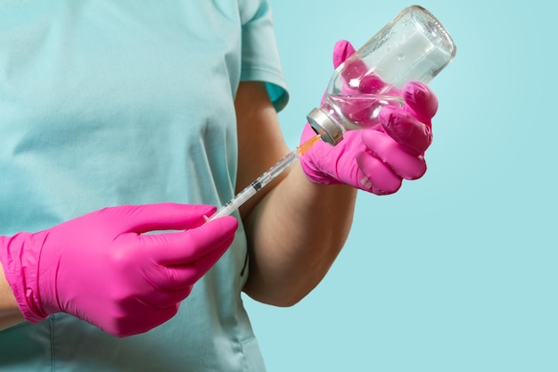 Siringa di plastica e bottiglia per medicina liquida nelle mani