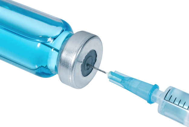 Siringa medica con l'ago nella fiala con vaccino blu isolato