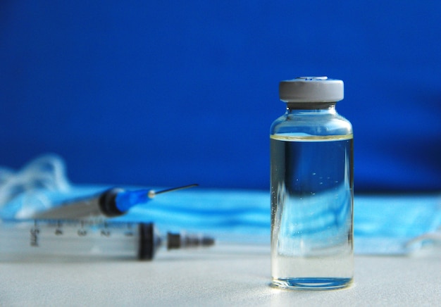 siringa monouso con vaccino e mascherine mediche blu