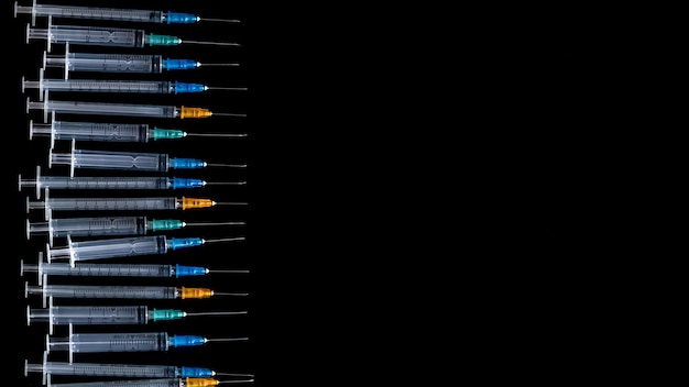 Siringhe mediche con ago su sfondo nero, siringa ravvicinata, concetto di assistenza sanitaria.