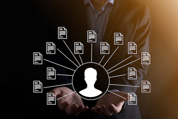 Sistem Manajemen Dokumen DMS. Pengusaha memegang ikon pengguna dan dokumen. Perangkat lunak untuk mengarsipkan, mencari, dan mengelola file serta informasi perusahaan. Konsep Teknologi Internet. Keamanan digital.
