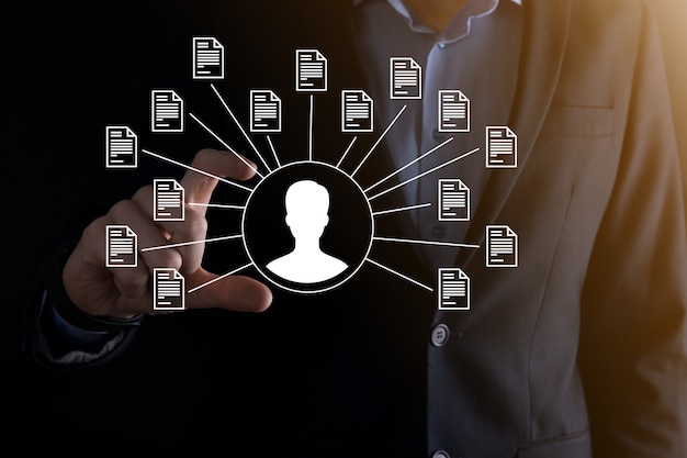 Sistem Manajemen Dokumen DMS. Pengusaha memegang ikon pengguna dan dokumen. Perangkat lunak untuk mengarsipkan, mencari, dan mengelola file serta informasi perusahaan. Konsep Teknologi Internet. Keamanan digital.