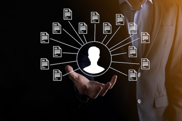 Sistem Manajemen Dokumen DMS. Pengusaha memegang ikon pengguna dan dokumen. Perangkat lunak untuk mengarsipkan, mencari, dan mengelola file serta informasi perusahaan. Konsep Teknologi Internet. Keamanan digital.