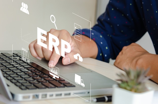 Sistema software ERP (Enterprise Resource Planning) per i piani delle risorse aziendali. concetto mano digitando le icone del computer portatile sullo schermo virtuale.