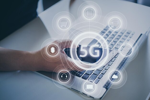 Sistemi wireless di rete 5G e Internet delle cose con la mano di un giovane utilizzando smartphone e laptop