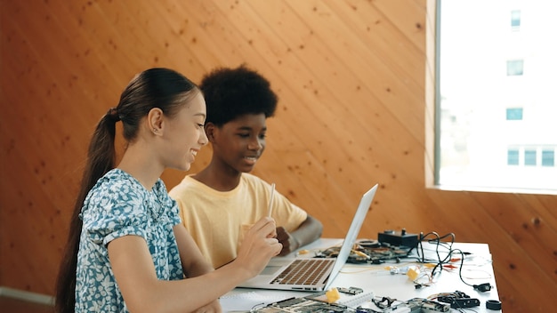 Site view of african boy and girl working together to code prompt Edification
