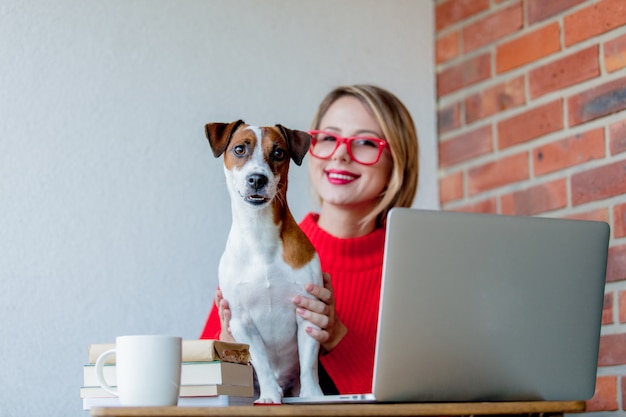 sititng ragazza al tavolo con computer e cane