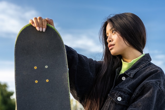 Skateboarder femminile teenager alla moda alla moda allo skate park