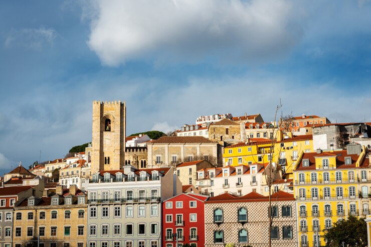 Skyline con le torri della cattedrale e le case colorate del quartiere Alfama a Lisbona in un pomeriggio d'inverno nuvoloso.